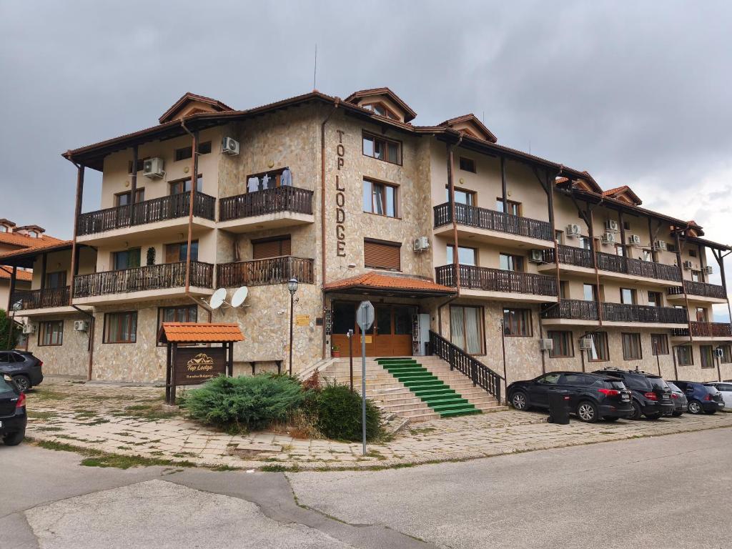 een groot gebouw met auto's ervoor geparkeerd bij Apartament 4 seasons - Top Lodge in Bansko