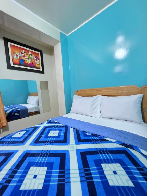 a blue room with a bed with a blue and white blanket at Hospedaje Leo in Lima