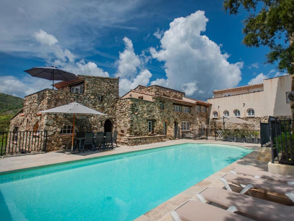 een zwembad met stoelen en parasols voor een gebouw bij vakantiewoning Emponse 7 in Plan-de-la-Tour