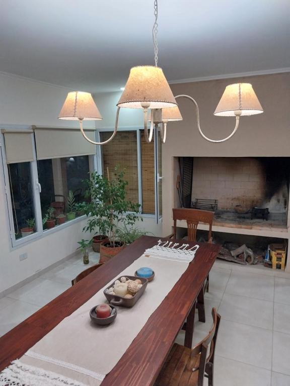 a dining room with a wooden table and two lights at Felicità in Realicó
