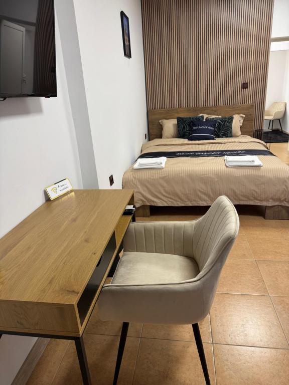 una habitación con dos camas y un escritorio y una silla en River Garden House, en Vidin