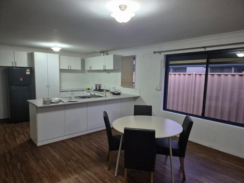 a kitchen with a table and a table and chairs at Dalyellup 2BR accommodation-Rear Guest house Unit- Walkable to major supermarkets in North Boyanup