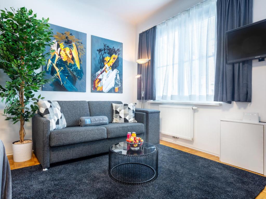 a living room with a couch and a table at Superior Studio at St Stephen's Cathedral City Center - 1 min walk to Vienna City Center in Vienna