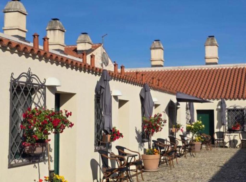 a patio of a building with chairs and flowers at Historic Han Hideaway in Vrana