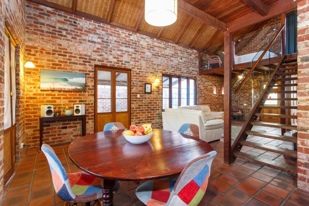 ein Esszimmer mit einem Holztisch und Stühlen in der Unterkunft Burn Street Loft - North Fremantle in North Fremantle