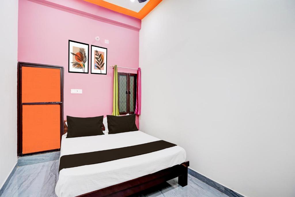 a bedroom with a bed in a room with pink walls at Hotel O ORM Inn in Bāra Banki