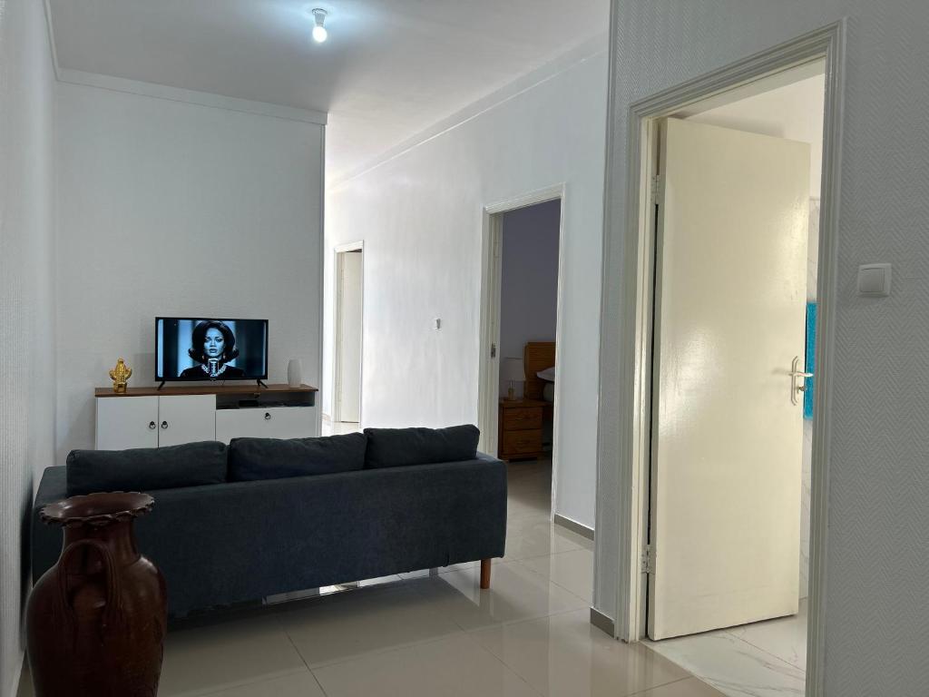 a living room with a blue couch and a tv at Sun & Sea Tarrafal in Tarrafal