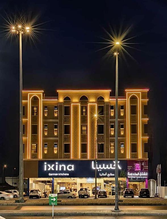 a building with two street lights in front of it at روز الخيال للشقق المخدومة 2 in Al Kharj