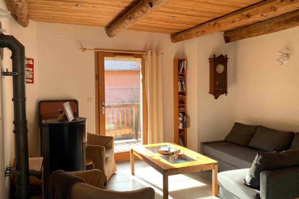 een woonkamer met een bank en een tafel bij Village House In The Heart Of Saint Chaffrey in Saint-Chaffrey