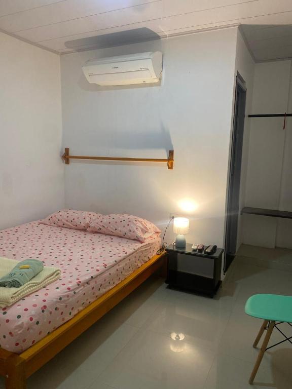 een slaapkamer met een bed, een lamp en een tafel bij Hotel Boutique 51 in Barrancabermeja