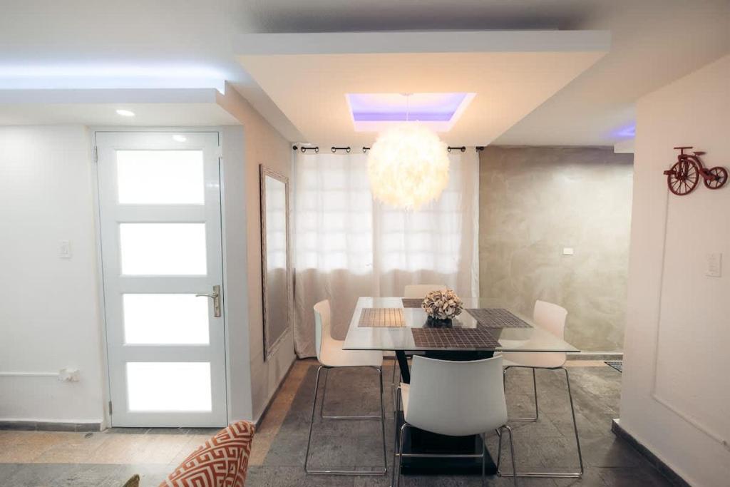 a dining room with a table and white chairs at Cayenne Cozy Apt with Generator and Cistern in Bayamon in Sierra Linda