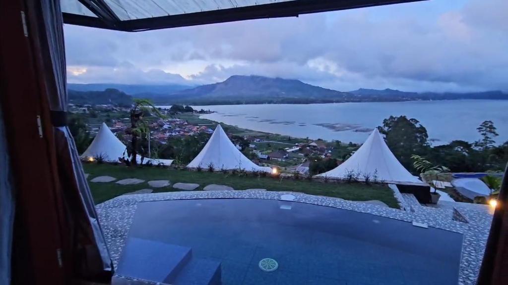 a view from a room with a view of the water and tents at Adelisca Glamping, Villa and Cafe in Kubupenlokan