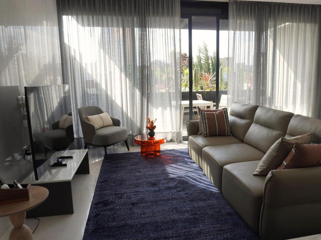 a living room with a couch and chairs and a television at Poe 227 By Ömora in Mexico City