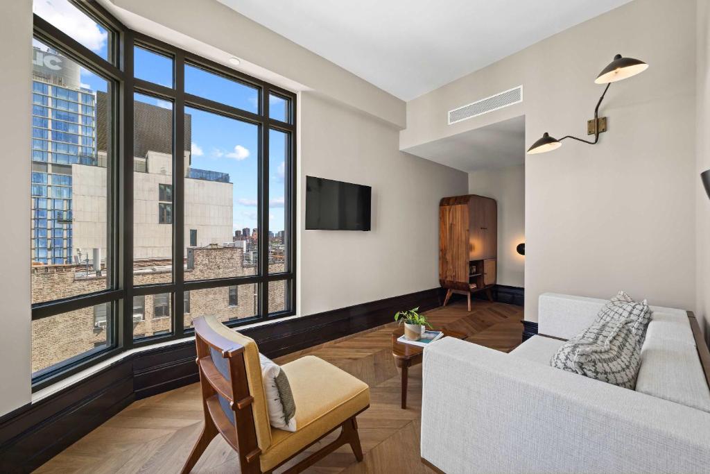 a living room with a white couch and a large window at Freeman 303 by Rove - 1BR Condo with Shared Amenities in New York