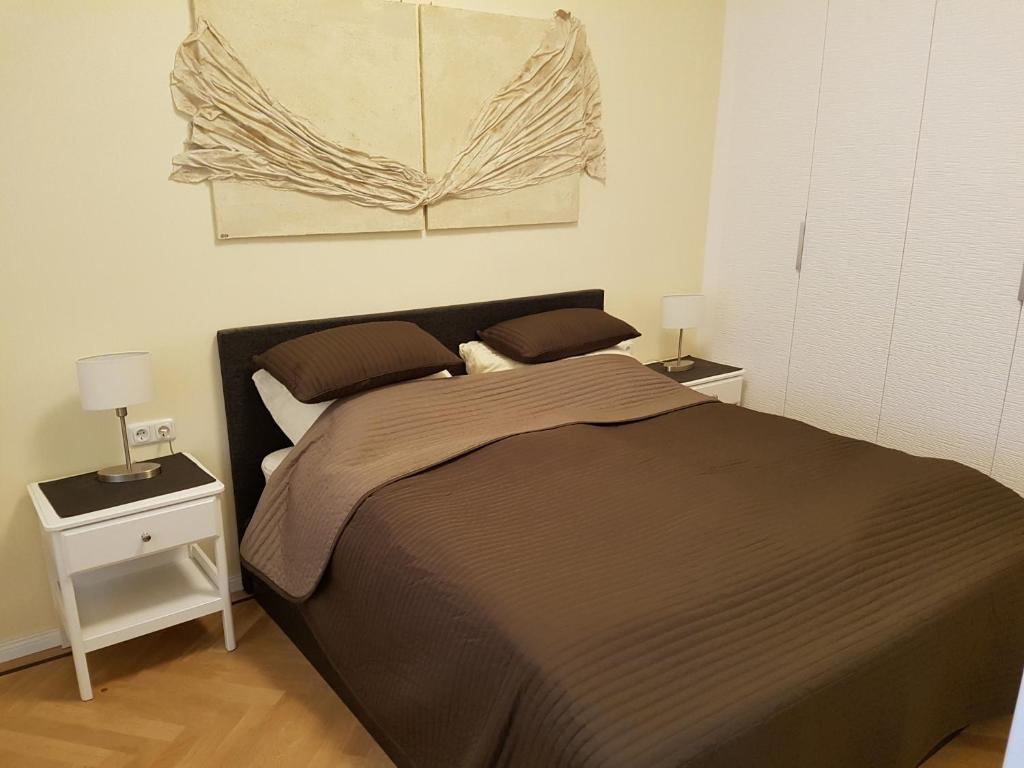 una camera da letto con un letto con due comodini e due lampade di Ableidinger Apartments a Vienna