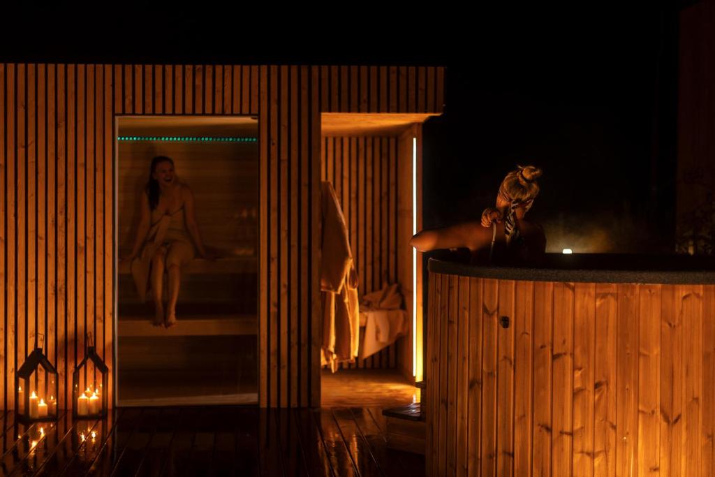 een kamer met een afbeelding van een vrouw die op een bed zit bij Hill & Chill Kudowa Zdrój - nowoczesne stodoły ze strefą SPA, balia, sauna in Kudowa-Zdrój