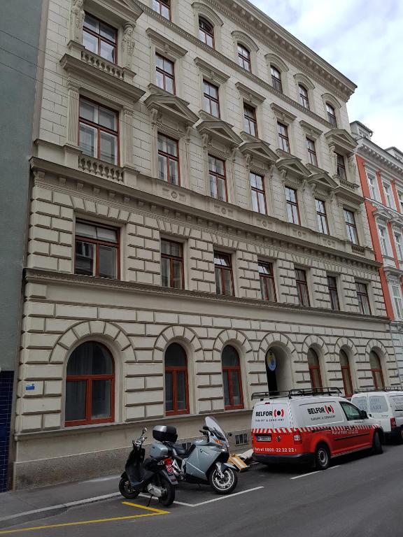 un furgone e una moto parcheggiati di fronte a un edificio di Ableidinger Apartments a Vienna