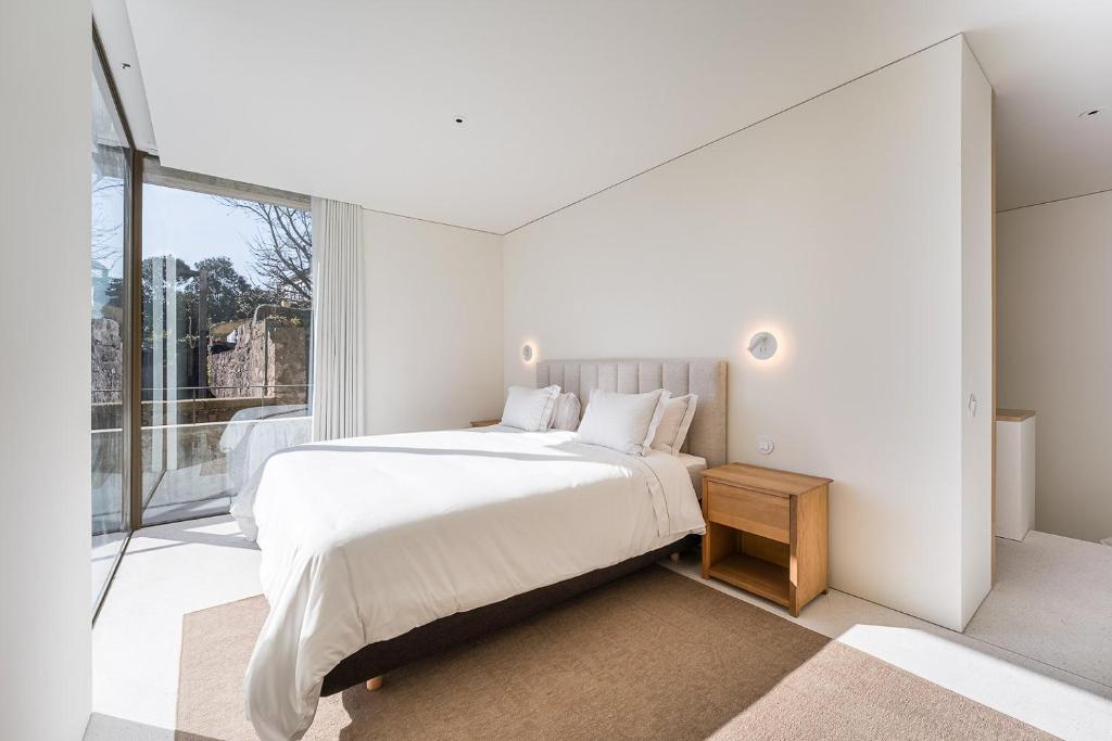 Un dormitorio blanco con una cama y una ventana grande. en GuestReady - DPV GuestHouse - Apart 6, en Oporto
