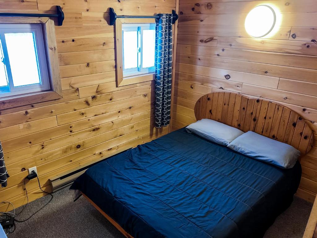 a bedroom with a bed in a wooden cabin at Winter at Wildwood in Bailieboro