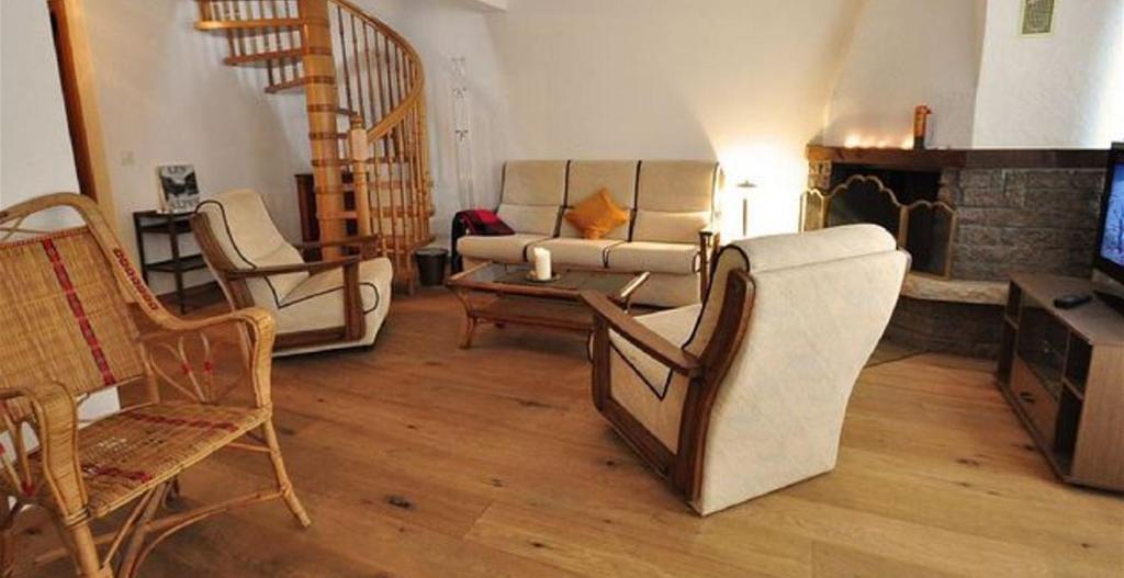 a living room with a couch and chairs and a tv at Gorgeous Home Saser in Santa Cristina in Val Gardena