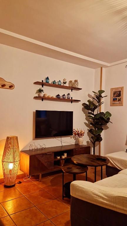 a living room with a television and a table at La Casa del Senderista in Arroyo Frio