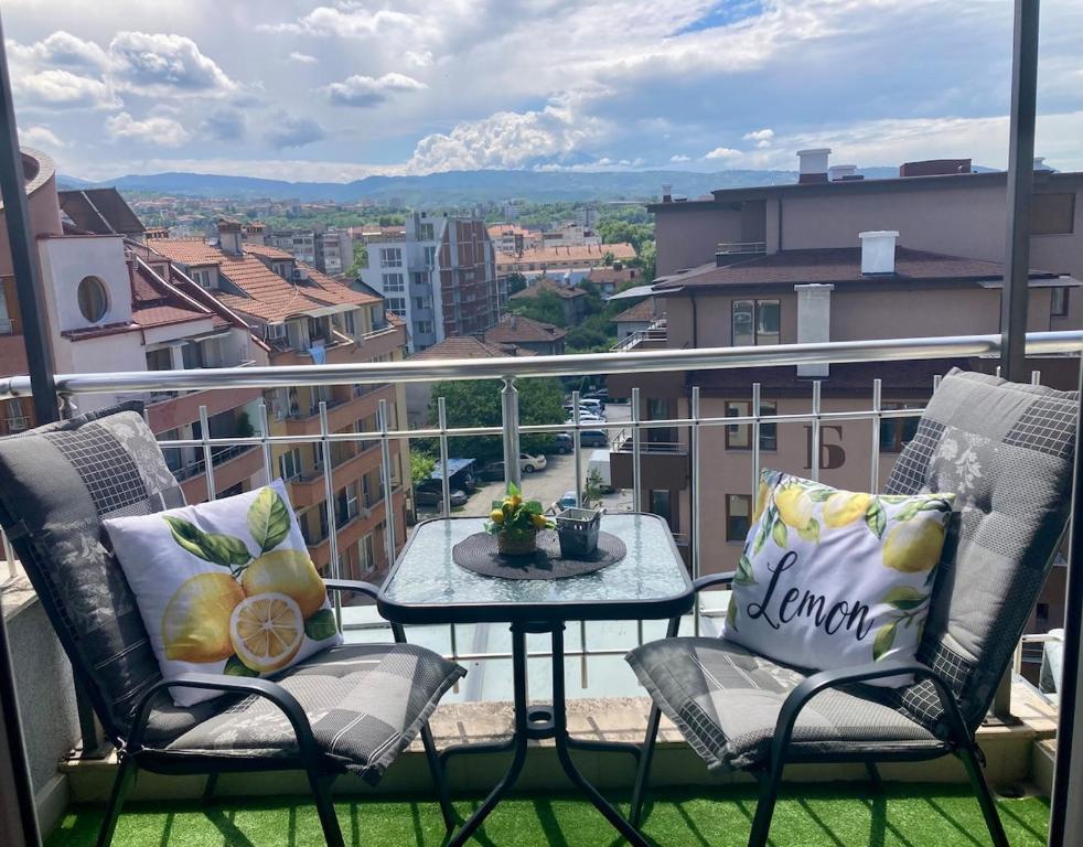 a balcony with two chairs and a table with a view at Cozy apartment Alba with two bedrooms! in Blagoevgrad