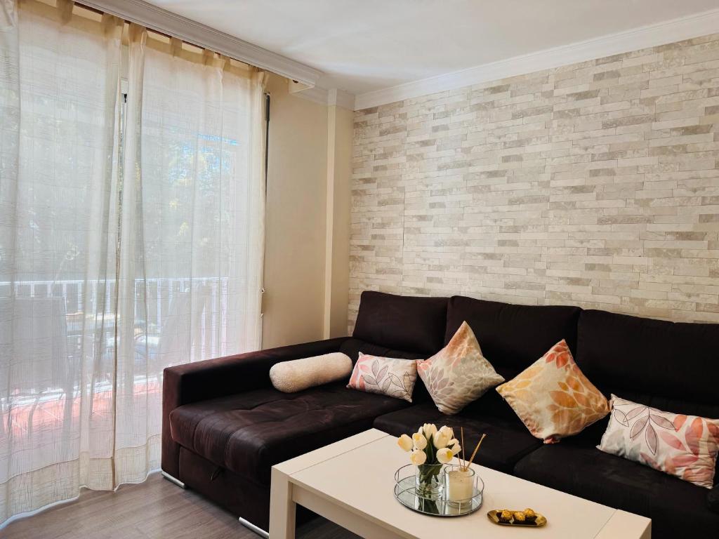 ein Wohnzimmer mit einer Ledercouch und einem Tisch in der Unterkunft Comodidad cerca del centro Granada in Albolote