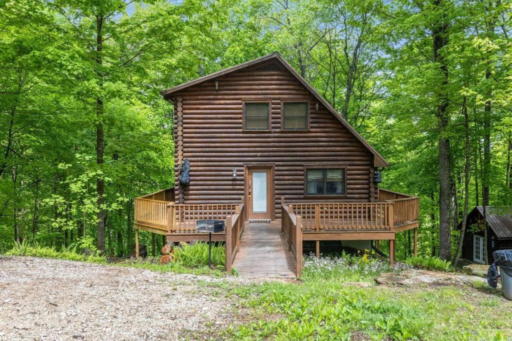 a log cabin in the woods with a porch and a deck at Hot Tub & WiFi - Birdsong - Red River Gorge KY in Stanton
