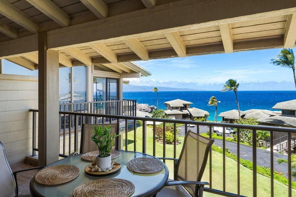 a table on a balcony with a view of the ocean at Kapalua Bay Villas 32B4 · KBV 32B4 Oceanfront Kapalua Spectacula in Kahana