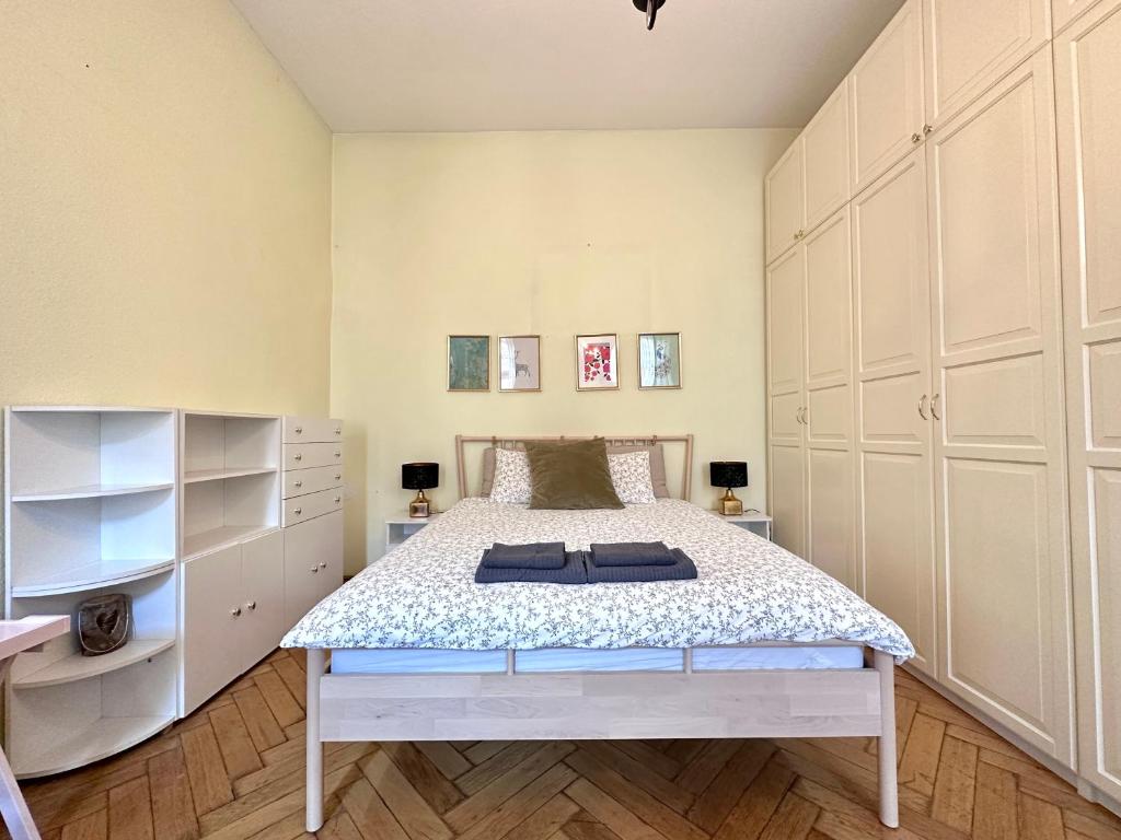 una camera da letto con un letto con armadi bianchi di 布达佩斯市中心西火车站公寓 a Budapest