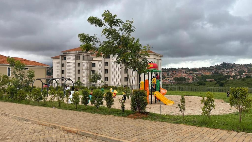 a playground in front of a large building at Eric Wilkins villas in Kampala