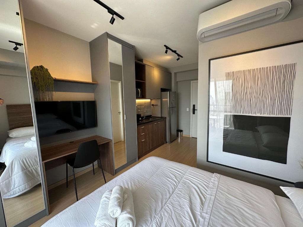 a bedroom with a white bed and a large mirror at Stay In- Consolação - conforto e acolhimento com uma vista incrível em uma excelente localização Portaria 24h in Sao Paulo