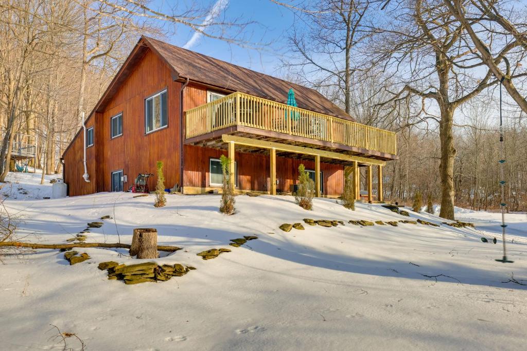 una casa en la nieve delante de una casa en Spacious Canandaigua Group Getaway House and Barn!, en Honeoye