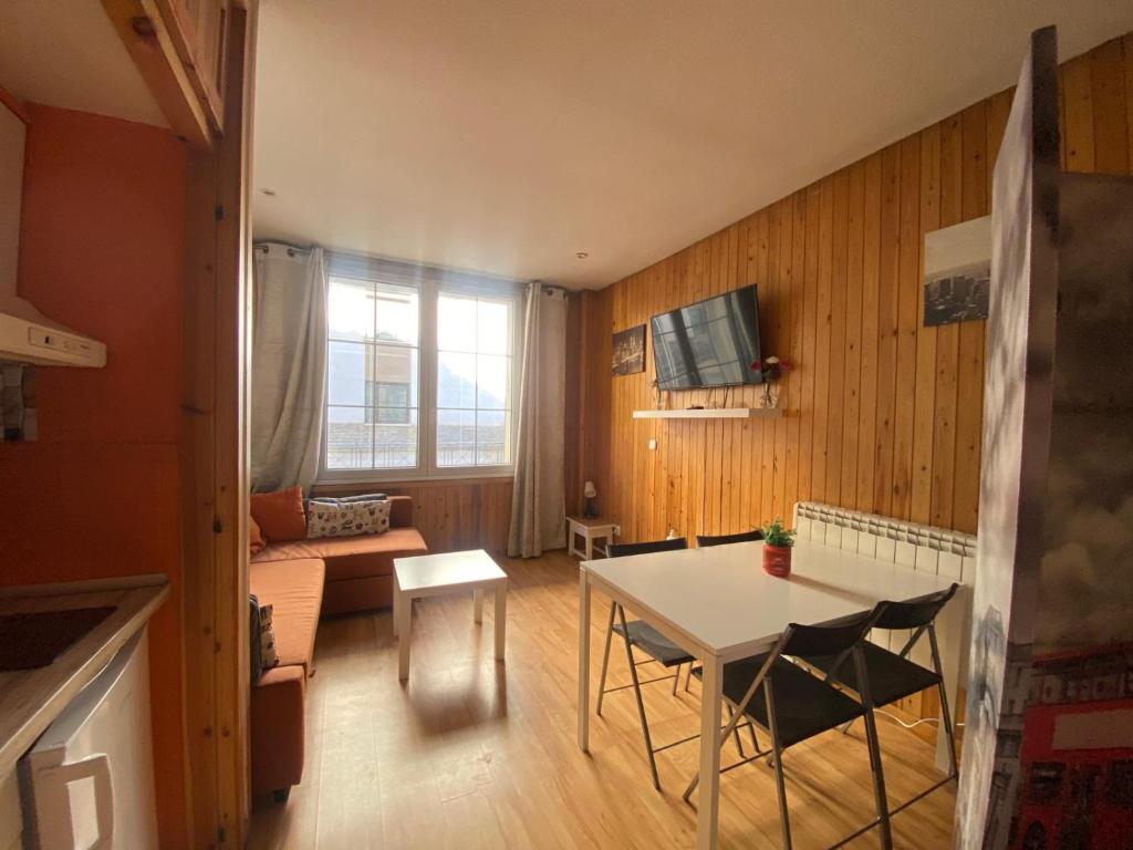 Una pequeña sala de estar con una mesa y un sofá. en GRAN ESTUDiO MARIBEL, en Sierra Nevada