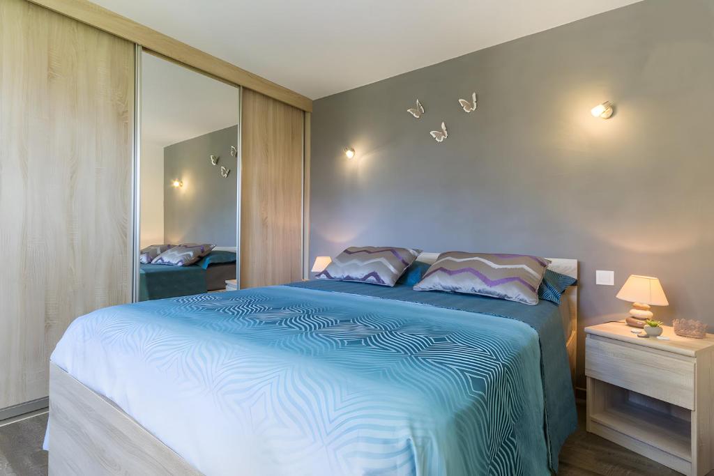 ein Schlafzimmer mit einem Bett mit einer blauen Bettdecke in der Unterkunft Gîte Le Rêve, Entre Lac Et Montagne in Viviers-du-Lac