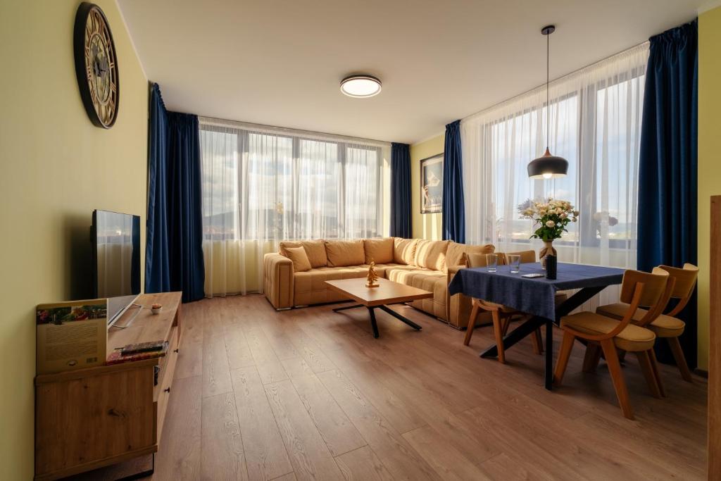 een woonkamer met een bank en een tafel bij Rila Sunshine Apartment in Samokov