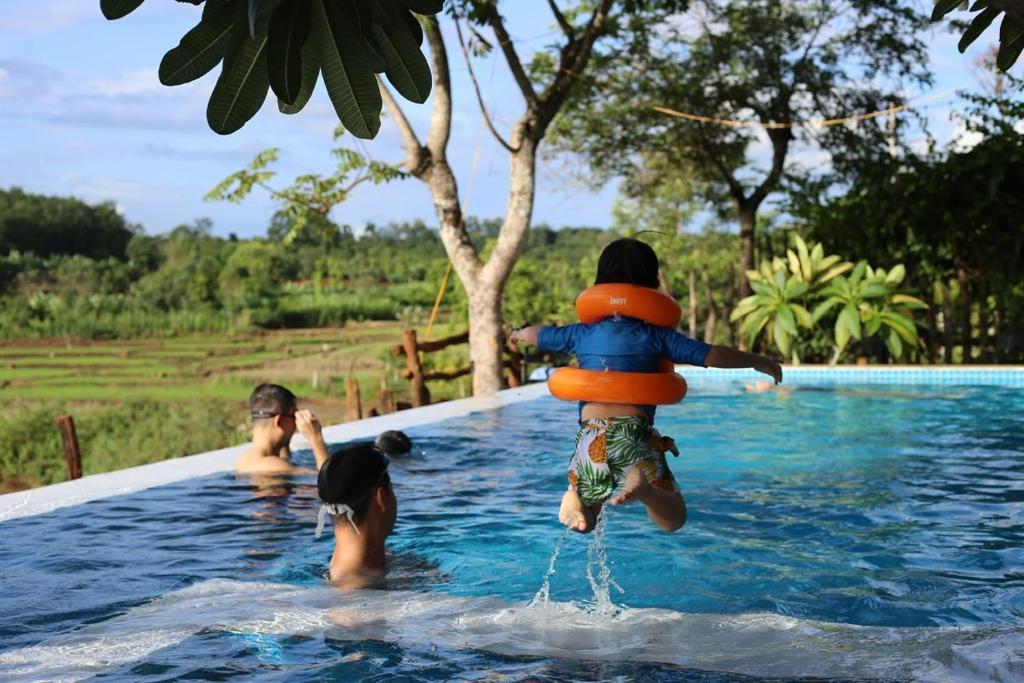 a group of people in a swimming pool at Villa Đăng Hải in Buôn Du Enguôl