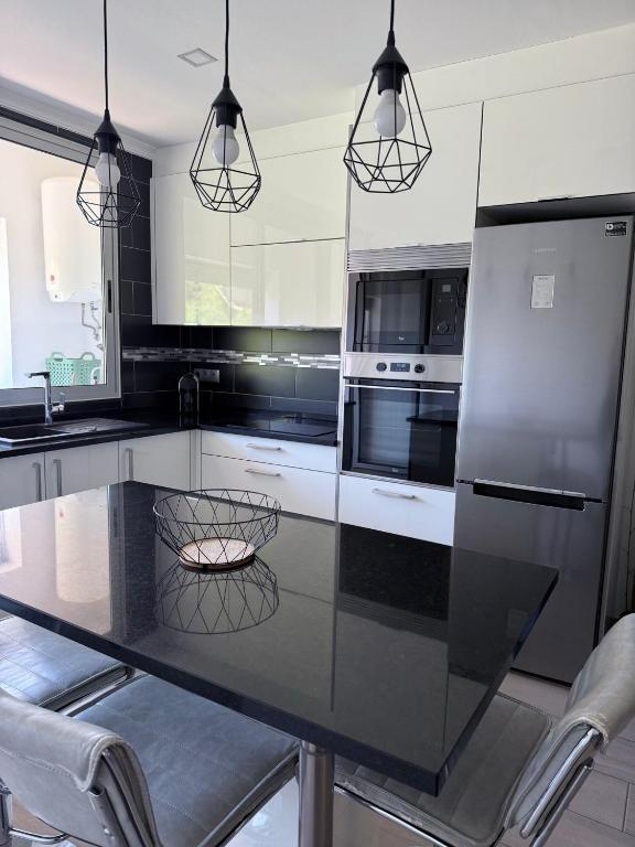 een keuken met een zwart aanrecht en apparatuur bij Apartamento Machadinho in Vale de Pedras