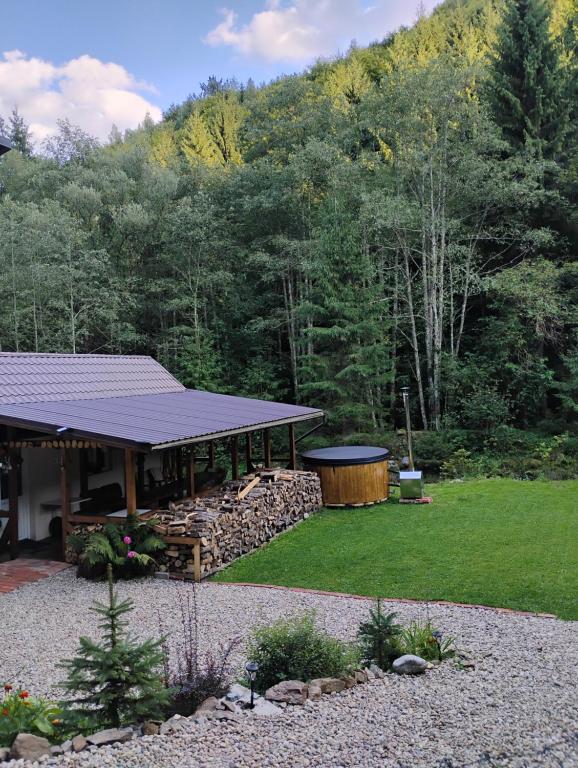 une maison avec un kiosque dans une cour dans l'établissement Cabana de la râu! Ciubăr aero hidro masaj, à Măguri-Răcătău