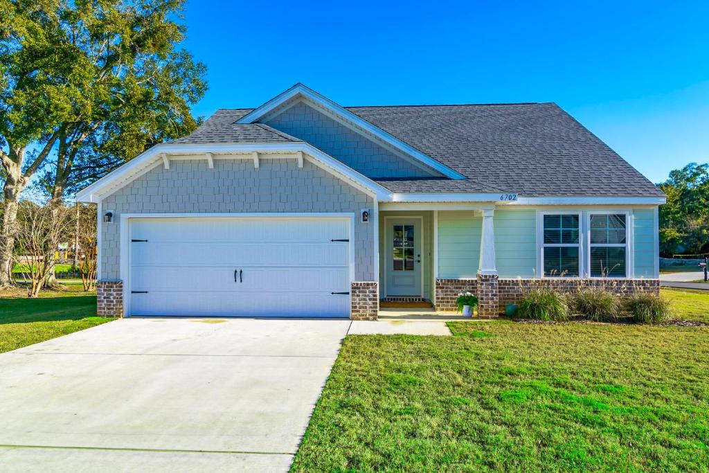 a house with a garage in a yard at BRAND NEW, fully furnished 3 bedroom, 3 bathroom home in Ocean Springs! in Gulf Hills