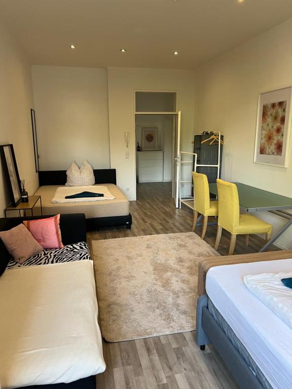 a room with two beds and a table and chairs at Private Room in Shared Apartment in Berlin