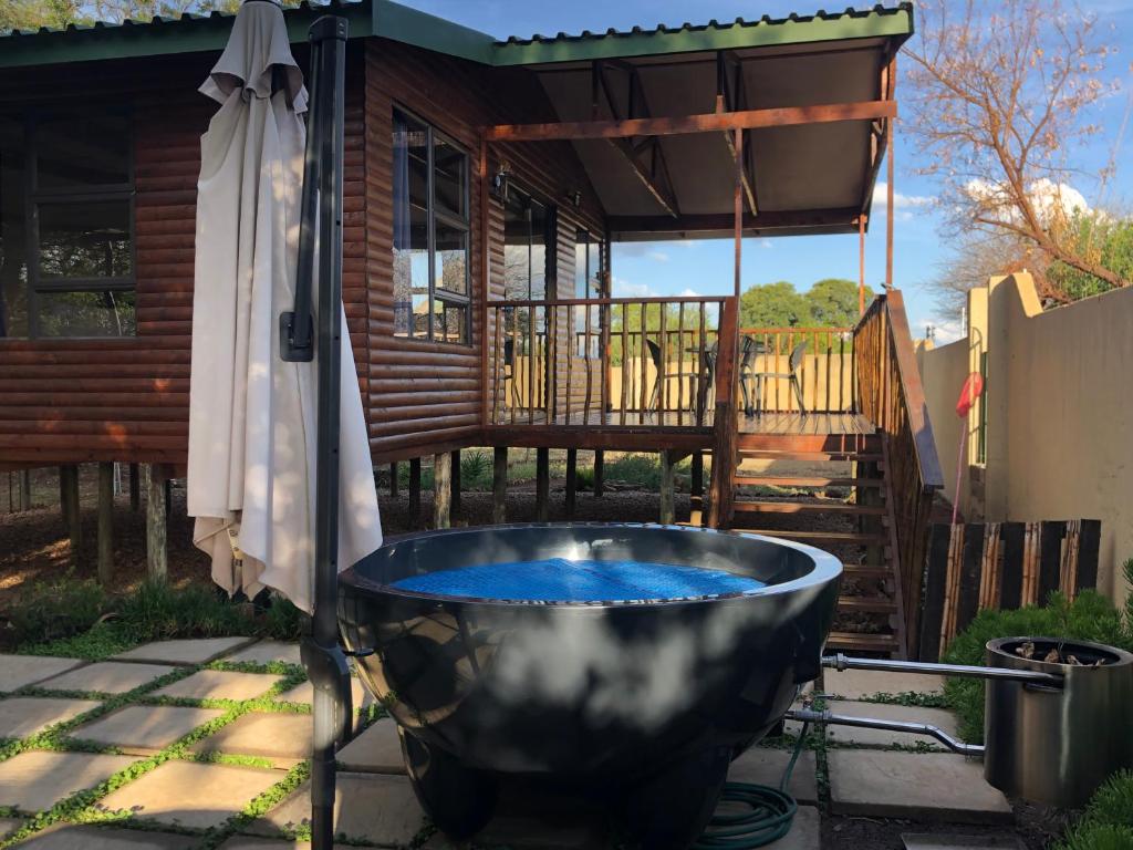 a bath tub filled with blue water on a patio at Romantic cabin in Big 5 Reserve in Dinokeng Game Reserve