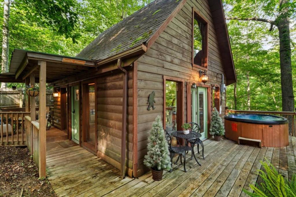 a log cabin with a hot tub on a deck at Hot Tub & WiFi - Romantic Hideaway in Slade