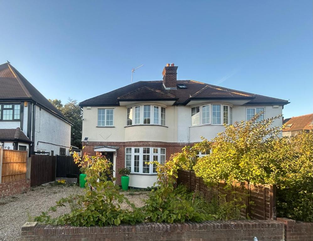 a white house with a fence in front of it at Eastcote 1st Floor Retreat 2 Bedroom Suite with Kitchen and Bathroom 2mins to Tube 20mins to Heathrow and Wembley 25mins Drive to Harry Potter World FREE PARKING in Eastcote