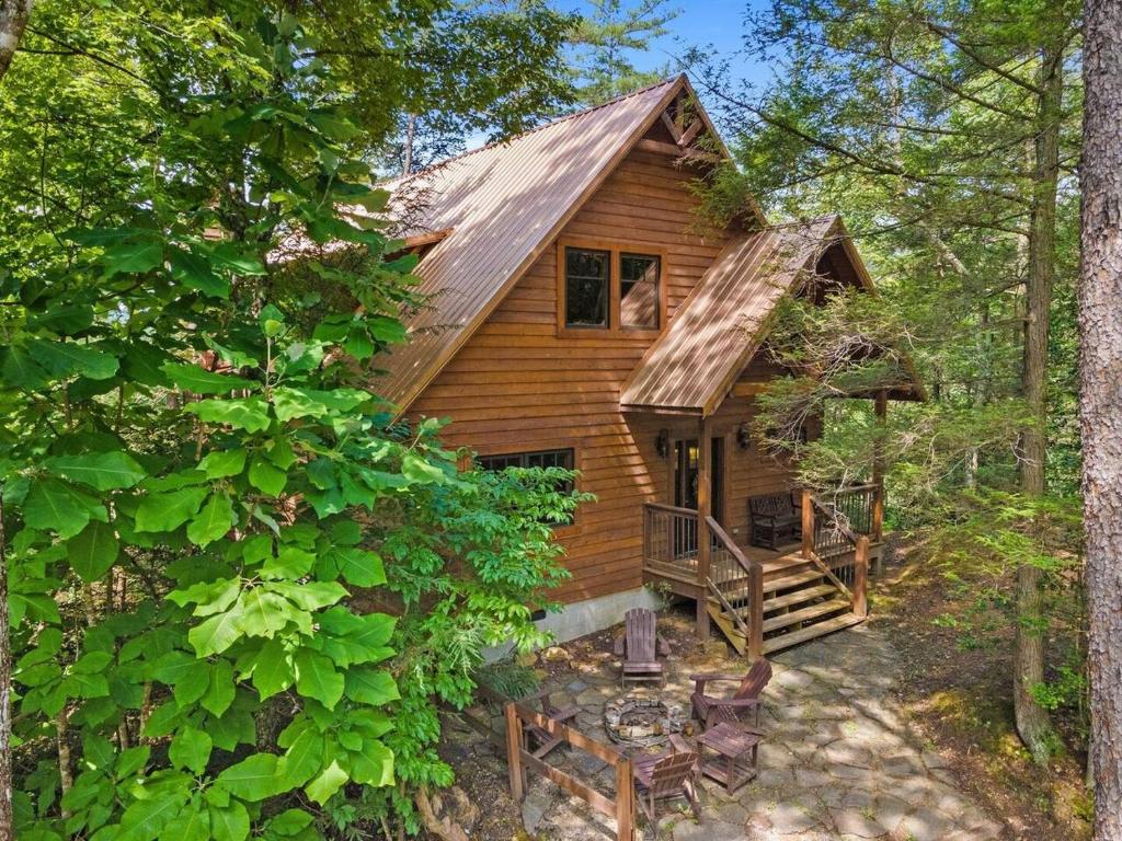 a log cabin in the woods with a porch and stairs at Hot Tub & WiFi - Sky Pointe - LUX cabin in RRG KY in Rogers