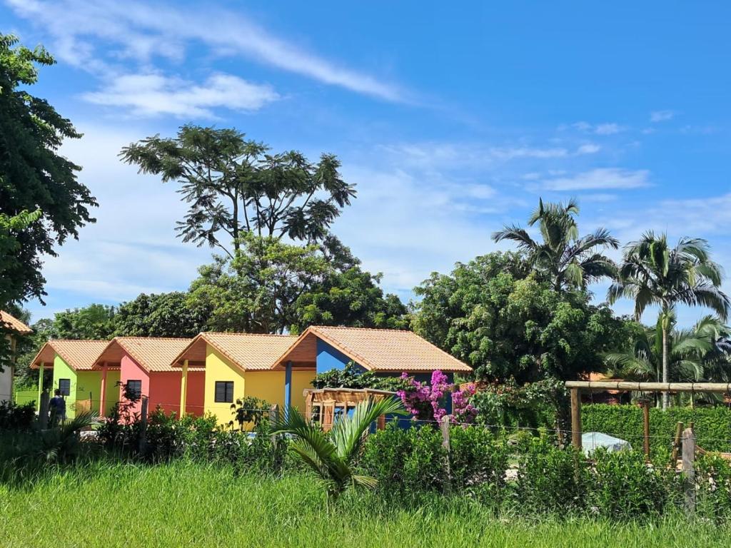 a row of colourful houses in a field at Chalés Quintal da Serra in Lavrinhas