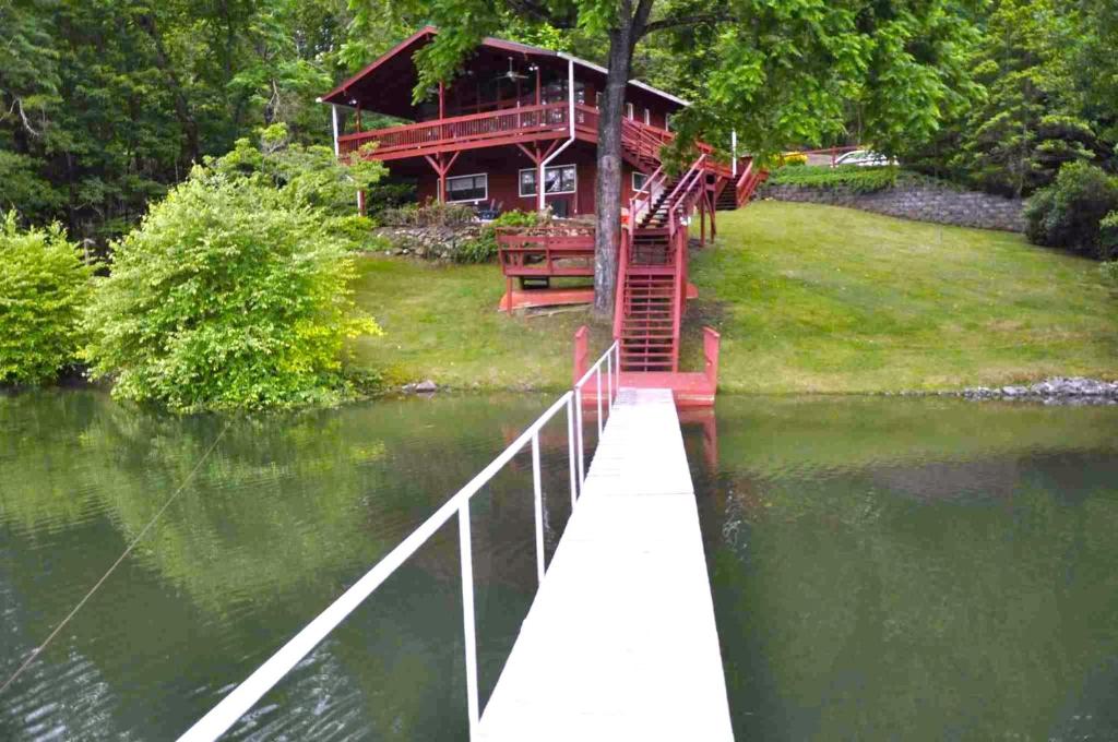 a house on the shore of a lake with a bridge at Chatuge Fish Retreat in Hiawassee