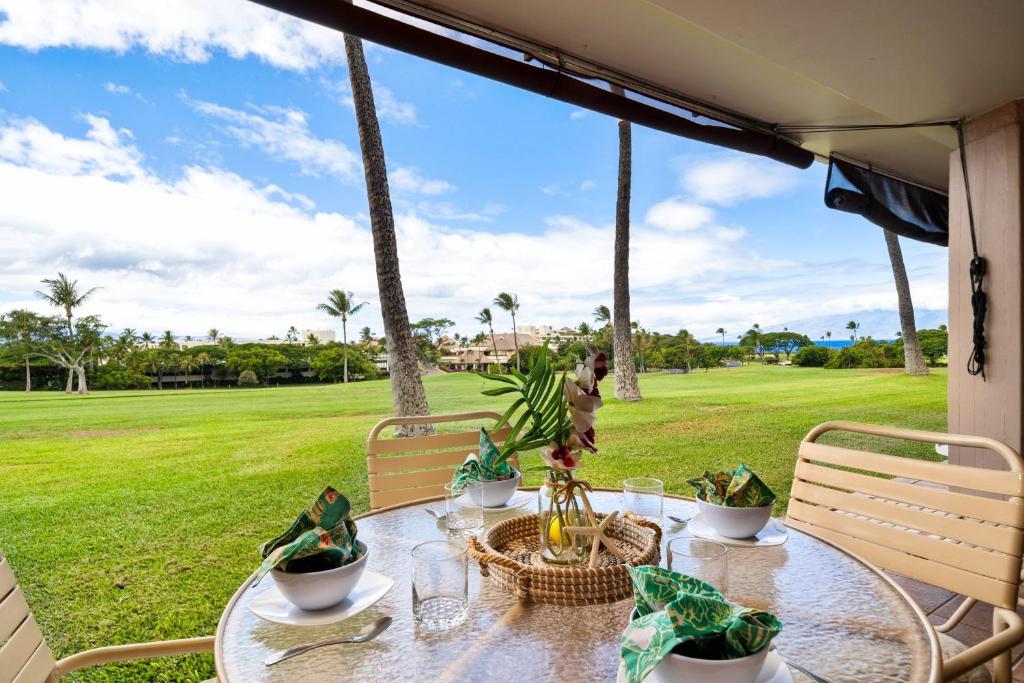 a dining table with a view of a golf course at Eldorado A108 in Kaanapali