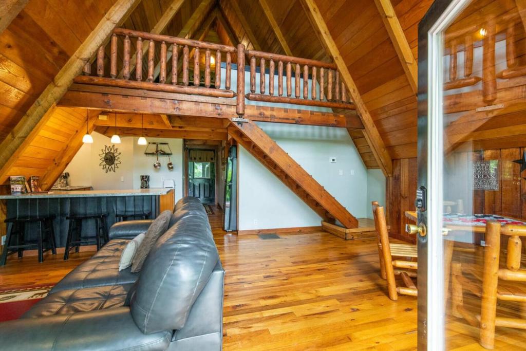 een woonkamer met een bank en een trap bij Hot Tub - Haven at the Red - Red River Gorge KY in Slade