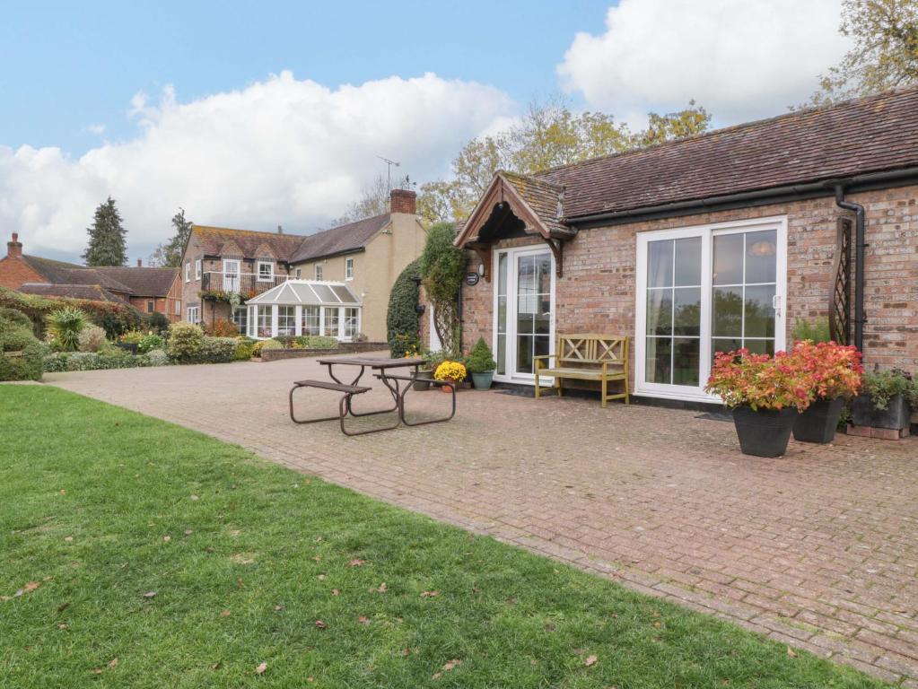 a patio with a picnic table and a building at Dovecote Cottage in Gloucester